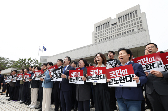 더불어민주당 의원들이 2일 서울 서초구 대법원 앞에서 열린 기자회견에서 이재명 대선 후보의 공직선거법 위반 사건 상고심 결과를 규탄하는 구호를 외치고 있다.<연합뉴스 사진>